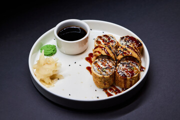 Sushi dish on white plate with sauce, table setting