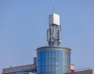 Gsm Cell Phone Communication Signal Antenna at Top of Modern Building Tower in City