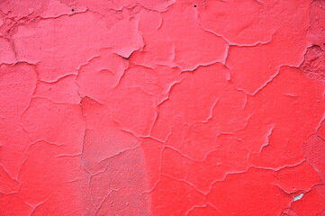 Scratched red wall with cracks. Red Cracked Background. Grunge concrete red cement wall with crack...