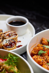 Close up of three bowls with fish ball, leaf vegetable, and plate on table