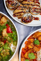 Close up of three bowls with fish ball, leaf vegetable, and plate on table
