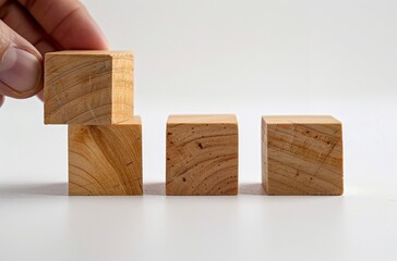 A hand is placing three wooden blocks in front of the camera, each block representing different layers or visions for business. The background should be white to highlight and emphasize these small 