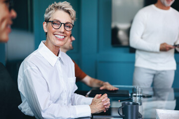 Caucasian business woman smiling happily in a team meeting at work