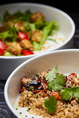 Close up of three bowls with fish ball, leaf vegetable, and plate on table
