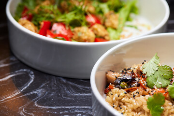 Close up of three bowls with fish ball, leaf vegetable, and plate on table