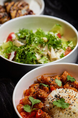 Close up of three bowls with fish ball, leaf vegetable, and plate on table