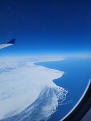 View from airplane flying above icy sea