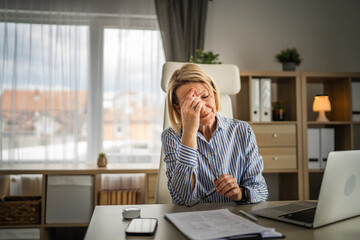 Mature woman have headache at office