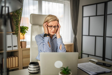 Mature woman have headache at office