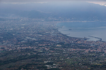 View from the top of Mount Vesuvius down to the city of Pompeii on a hazy winter day, Naples, Campania, Italy