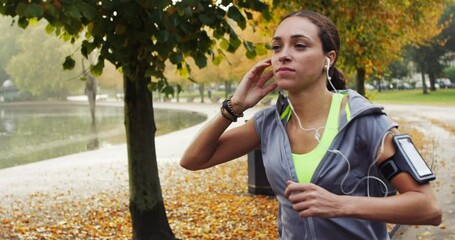 Woman with earphones, running in park and exercise outdoor for health, wellness and listening to music on workout. Speed, race and energy, runner with radio or podcast for entertainment and fitness