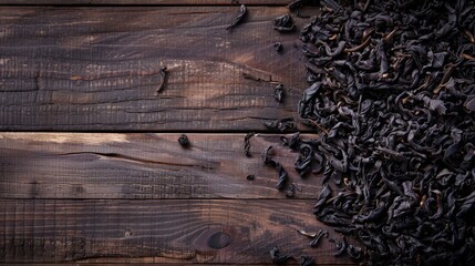 Dried black tea leaves on a rustic wooden surface