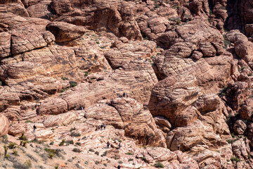 Spectacular view of red mountains at Sandstone Quarry stop. Hikers look like ants or miniature figures. It belongs to the world famous Scenic Drive road, a 13 mile loops with chilling natural views