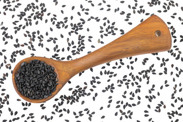 black sesame seeds in wooden spoon isolated on white background. Top view. Flat lay