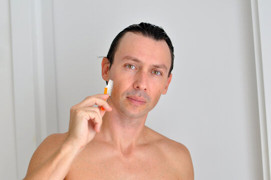homem com gilete tirando a barba 