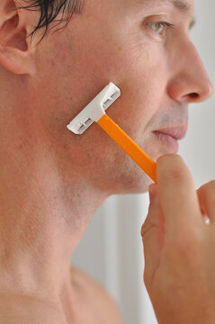 homem com gilete tirando a barba 