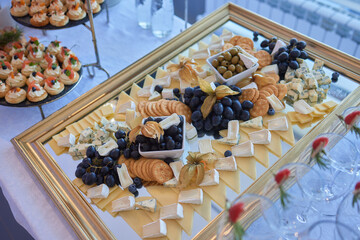 A tray of food with Gorgonzola next to a mirror on the table