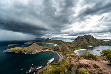 Image of incoming rain storm passing over Padar island with beautiful pink beaches and bays in Komodo national park, Indonesia