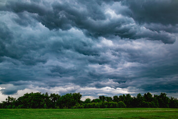 A stormy sky with dark clouds and a field of grass