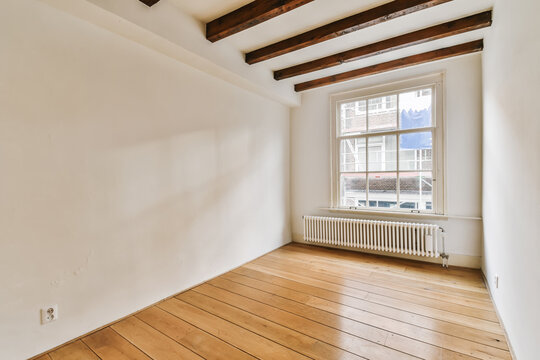 Bright and empty room with wooden floor and white walls