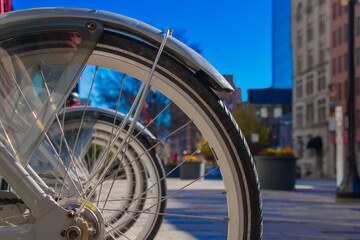 Naklejka premium City buildings viewed through a group of parked bicycles.