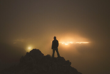 Climber gazing the citylights from the summit of Mt Olympus