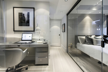 Modern home office with glass wall in bedroom, featuring sleek desk beside bed and framed poster on wall. White wood floor adds elegance.