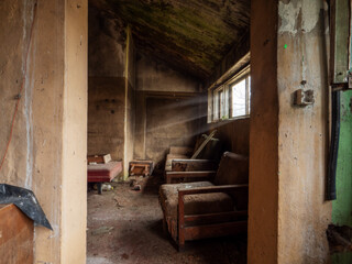 Dirty room in a abandoned house or in industrial shop in a war zone. Old furniture covered with...