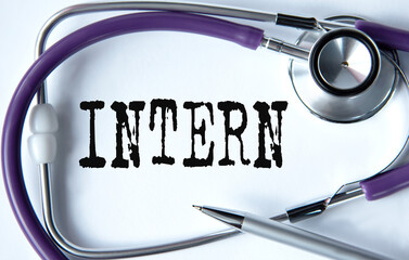 INTERN - word on white background with pen and stethoscope