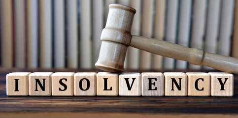 INSOLVENCY - word on wooden cubes on background of judge's gavel