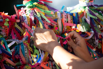 A Catholic faithful is seen tying a souvenir ribbon on the railing of the Senhor do Bonfim church in the city of Salvador, Bahia.