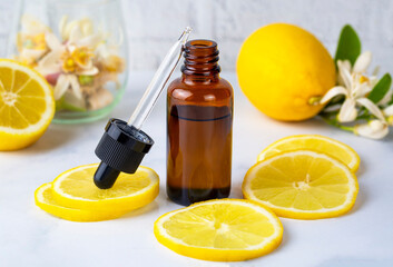 Fresh citrus essential oil. Lemon oil bottle with lemons fruits