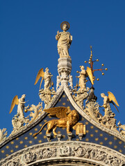 San Marcos statue above the Venice winged lion on the facade of St. Marks Basilica, Venice