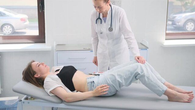 Doctor Conducting Abdominal Examination on Female Patient in Hospital Room
