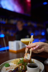 Sushi dish on white plate with sauce, table setting