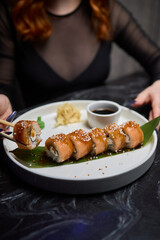 Sushi dish on white plate with sauce, table setting