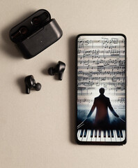 A phone with a picture of a man playing a piano on the screen. The phone is next to a pair of...