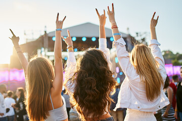 Group of female friends enjoying live music on sunny beach festival. Girls dance, celebrate with...