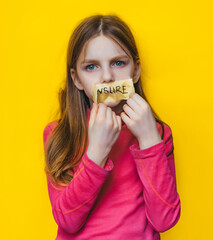 A child with his mouth taped peels off a piece of tape with the words "CENSURE" written on it. Yellow background. Ban on opinion, unwillingness to listen to children, restriction of freedom of speech.