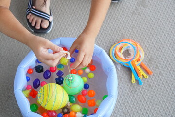 自宅で小学4年生の子供がヨーヨー釣りとスーパーボールすくいを楽しんでいる様子。