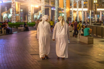 Zwei Menschen in Dubei gehen durch das Einkaufszentrum
 - obrazy, fototapety, plakaty