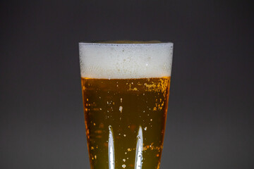 Cold beer dripping foam into glass