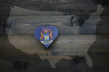 wooden heart with national flag of michigan state near united states of america map on the wooden...