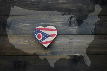 wooden heart with national flag of ohio state near united states of america map on the wooden...