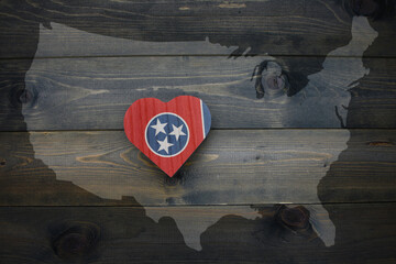 wooden heart with national flag of tennessee state near united states of america map on the wooden...