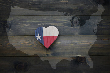 wooden heart with national flag of texas state near united states of america map on the wooden...