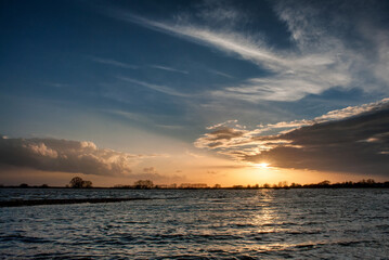 The swollen River Elbe near Tangermünde, Germany, floods its banks, depicting the raw power of nature in a scene of both awe and danger.