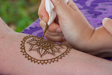 Henna application involves skillfully decorating skin with intricate patterns using a paste derived...
