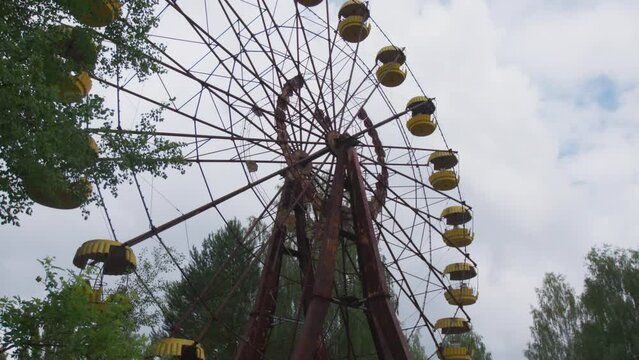 Abandoned Ferris wheel in the city of Pripyat. The whole playground was overgrown with greenery and trees. Consequences of the Chernobyl disaster.