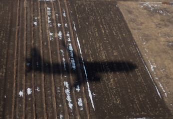 The shadow of an airplane on the ground during landing. A bird's-eye view of the earth.